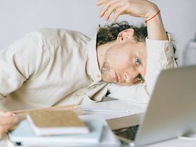 Mann mit Burnout vor Laptop