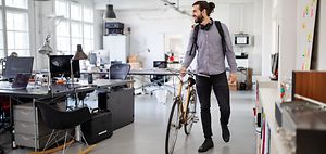 Mann mit Fahrrad im Büro