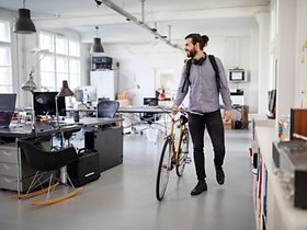 Mann mit Fahrrad im Büro