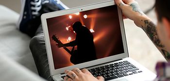 Mann mit Laptop auf Sofa