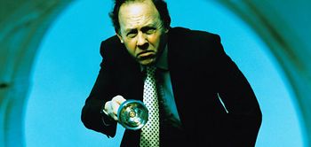 Mann mit Lupe in rundem Scheinwerfer