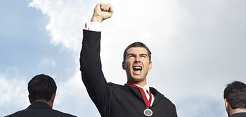 Mann mit Medaille um den Hals reckt Arm mit Faust in die Höhe