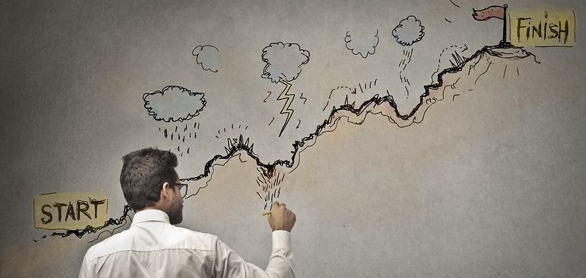 Mann mit Stift steht vor Start und Ziel Grafik