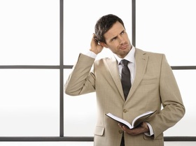 Mann mit Terminkalender kratzt sich am Kopf