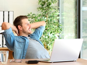 Side view of an entrepreneur relaxing and thinking sitting in a desktop and looking through a window