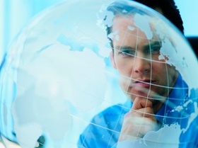 Mann schaut nachdenklich auf transparenten Globus