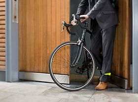 Mann schiebt Fahrrad aus Schuppen