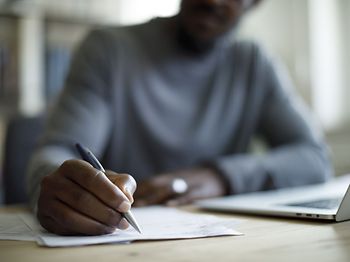 Mann schreibt auf Papier