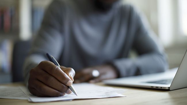 Mann schreibt auf Papier
