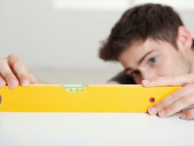 Mann setzt Wasserwaage an