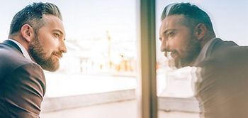 Mann spiegelt sich im Fenster