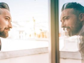 Mann spiegelt sich im Fenster
