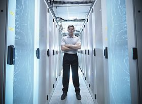 Mann steht mit gekreuzten Armen in einem Rechenzentrum