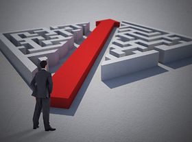 Mann steht vor Labyrinth mit einem roten Pfeil in der Mitte