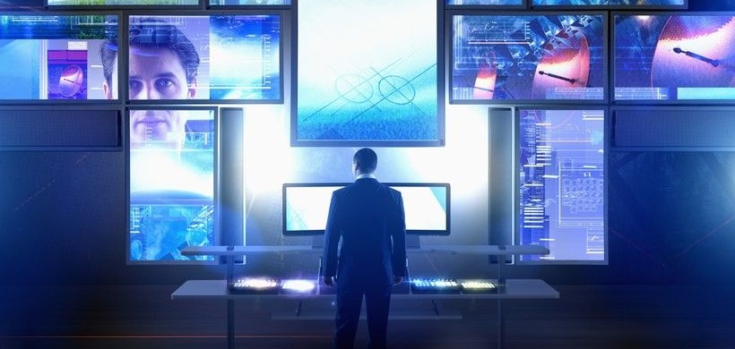 Mann steht vor vielen Bildschirmen, Digitalisierung