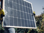 Mann trägt Solarpanel Handschuhe Wohngebiet