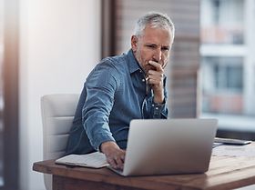 Mann überprüft konzentriert Geschäftsbericht