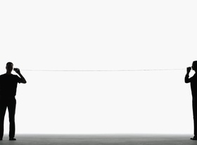 Mann und Frau sprechen durch Bechertelefon