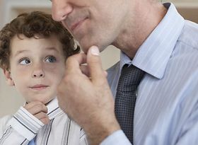 Mann und kleiner Junge fassen sich ans Kinn