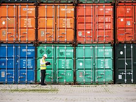 Mann vor Hafencontainern