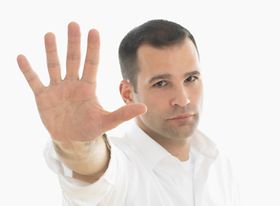 Mann zeigt flache Hand in die Kamera