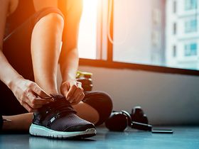 Mann zieht Sportschuhe an