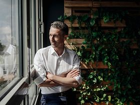 Mannam am Fenster Grün im Hintergrund