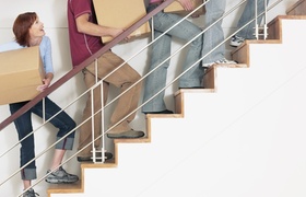 Menschen tragen Kartons eine Treppe hinauf