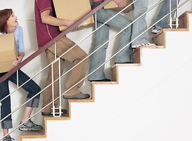 Menschen tragen Kartons eine Treppe hinauf