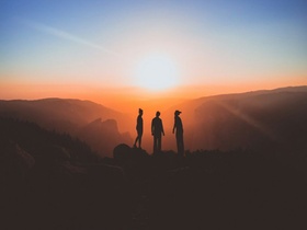 Menschen vor Sonnenaufgang in den Bergen