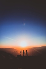 Menschen vor Sonnenaufgang in den Bergen
