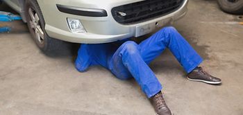 Minijobber der in Werkstatt Auto repariert