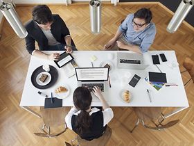 Mitarbeiter arbeiten beim Frühstück aus Vogelperspektive