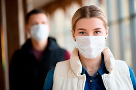 Man and woman wearing protective mask against transmissible infectious diseases and as protection ag