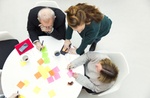 High angle view of business people with adhesive notes at table in creative office