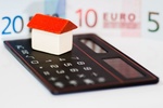 Modell-Haus Taschenrechner Geld im Hintergrund Wohngeld