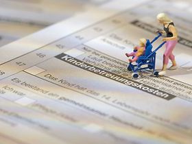 Modellfigur auf Steuererklärung und Kinderbetreuungskosten