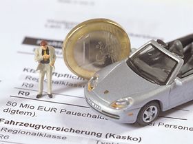 Modellporsche steht auf Versicherungsdokument