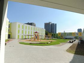 moderne, bunte Flüchtlingsunterkunft mit Spielplatz