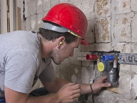 Ein Installateur, Anlagenmechaniker für Sanitär-, Heizungs- und Klimatechnik, verlegt eine Abwasserl