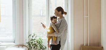 Mutter trägt Kind während dem arbeiten