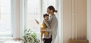 Mutter trägt Kind während dem arbeiten