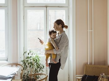 Mutter trägt Kind während dem arbeiten