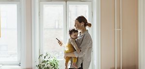 Mutter trägt Kind während dem arbeiten