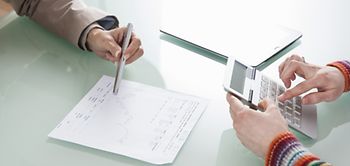 Nahaufnahme Hände zweier Menschen die Liniendiagramm besprechen