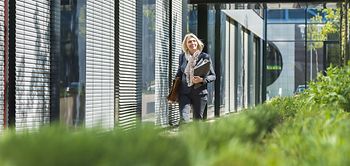 natürliche Businessfrau trägt Ordner und Brieftasche