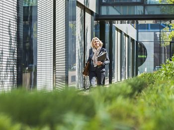 natürliche Businessfrau trägt Ordner und Brieftasche