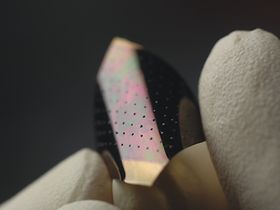 Neuartige Solarzelle in Fingern mit Schutzhandschuh