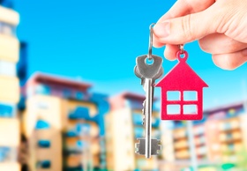 Mehrfamilienhäuser im Hintergrund Hand mit Schlüsselanhänger  