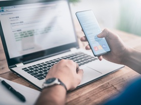 The man works at home and uses a smart phone and a notebook computer. Silhouette of a busy man. One